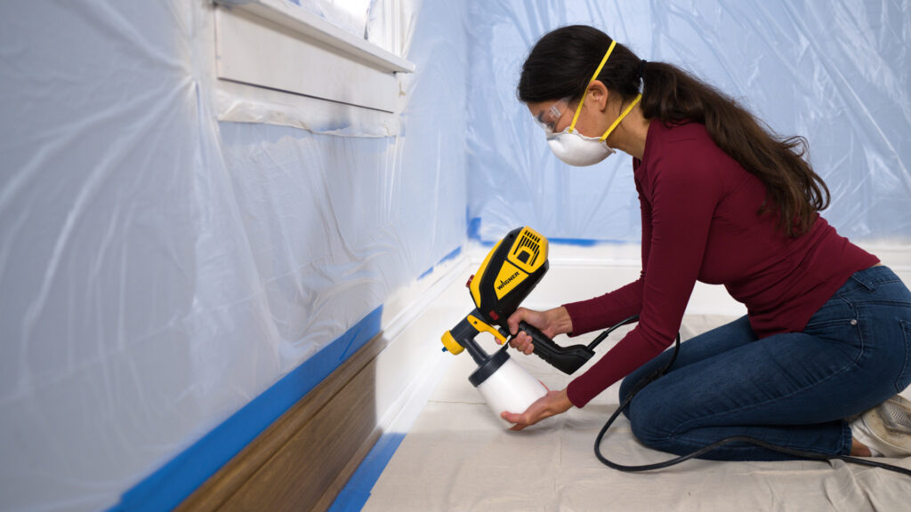 person spraying trim with the flexio 3500 paint and stain sprayer indoors