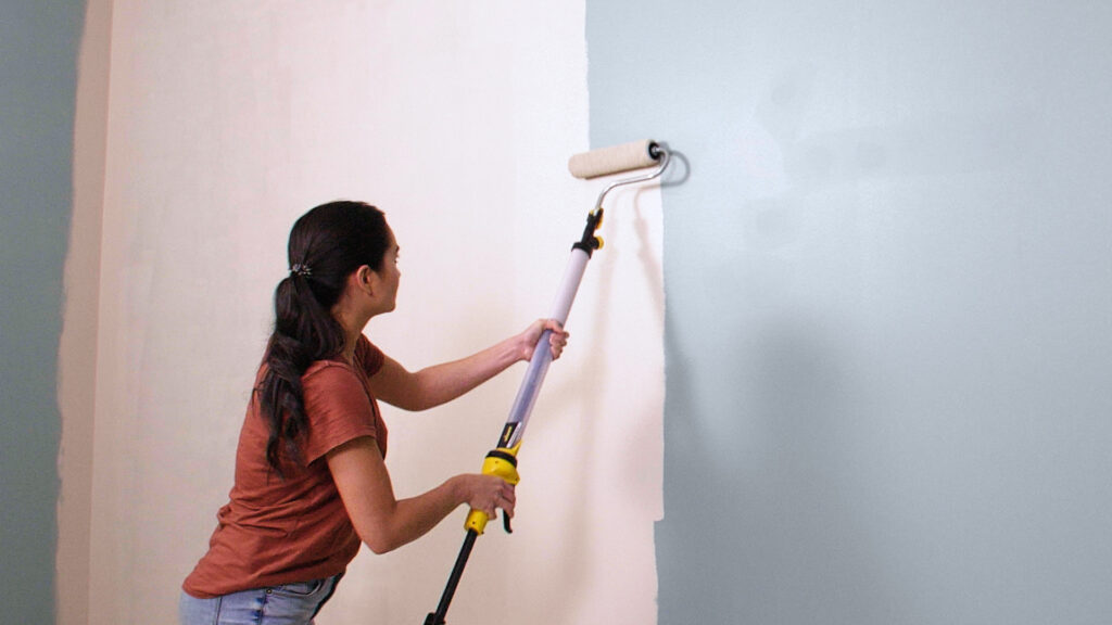 person painting a wall with the Paintstick Ez roller from Wagner
