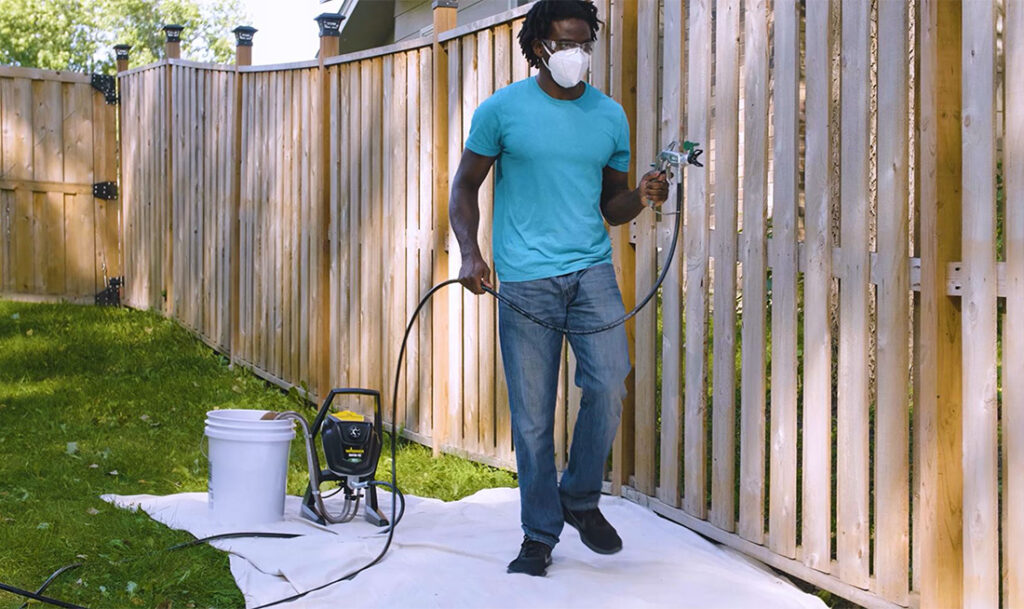 man walking with wagner sprayer in his hand 