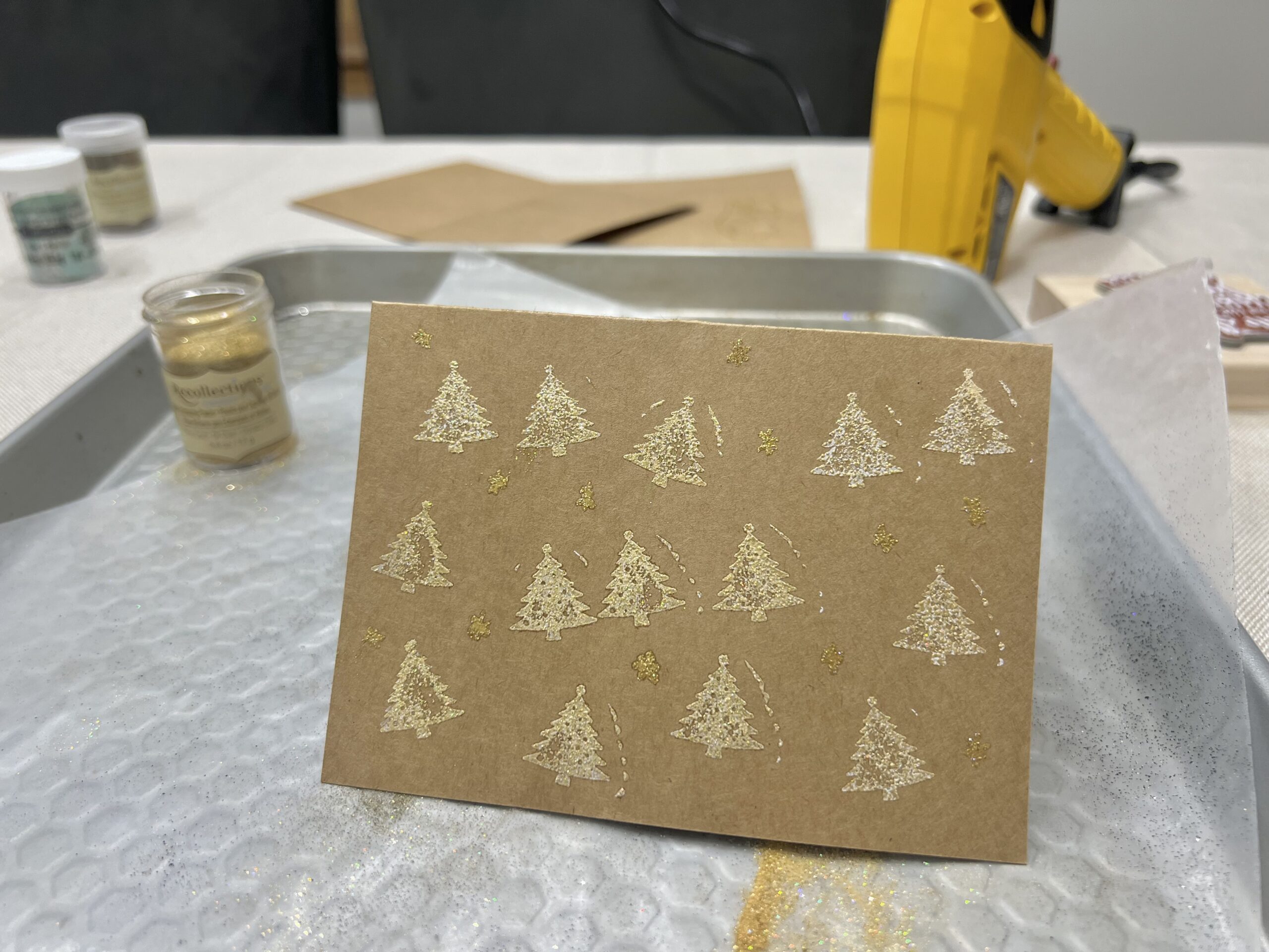 Embossed mini gold Christmas trees on a card