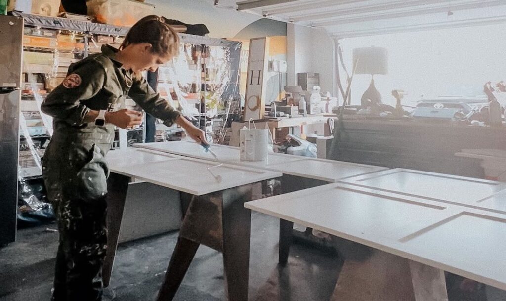 person painting cabinets with a paint roller